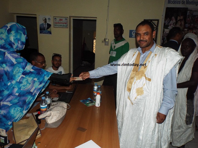 محفوظ ولد ابراهيم يسلم بطاقة تعريفه لمسؤولة الانتساب في مركز اللجنة الوطنية لنساء الحزب الحاكم 